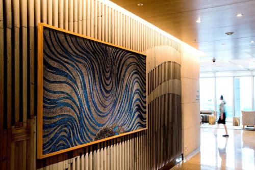 a large painting on a wall in a lobby at Lotte City Hotel Jeju Airport in Jeju