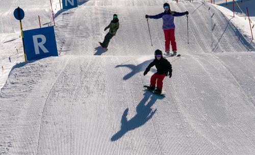 a group of people skiing down a snow covered slope at edelweiss lounge restaurant hotel pizza cafe billard gasthof in Mayrhofen