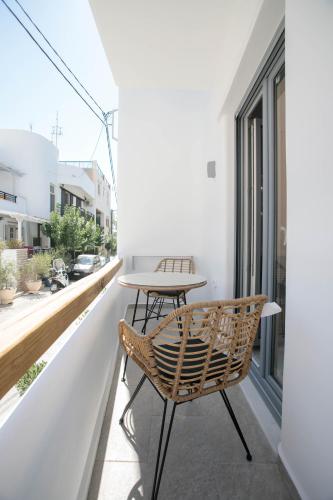 a patio with a table and chairs on a balcony at Majestique of Naxos luxury suites in Naxos Chora