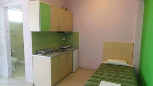 a kitchen with a sink and a bed in a room at Oniro Rooms & Suites in Leptokaria