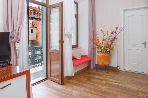 a living room with a red chair and a window at Hotel Nata in Tbilisi City