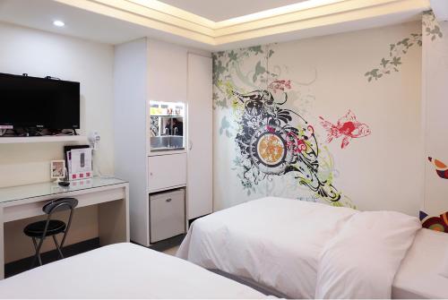 a bedroom with a bed and a desk and a tv at Beethoven Express Hotel in Zhongli