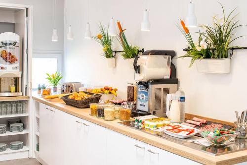 a kitchen with a counter with food on it at KYRIAD LYON EST – Saint Quentin Fallavier in Saint-Quentin-Fallavier