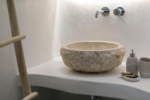 a bathroom sink with a bowl on a counter at Majestique of Naxos luxury suites in Naxos Chora