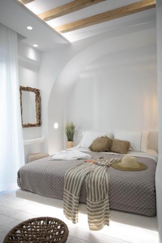 a bedroom with a large bed in a white room at Majestique of Naxos luxury suites in Naxos Chora