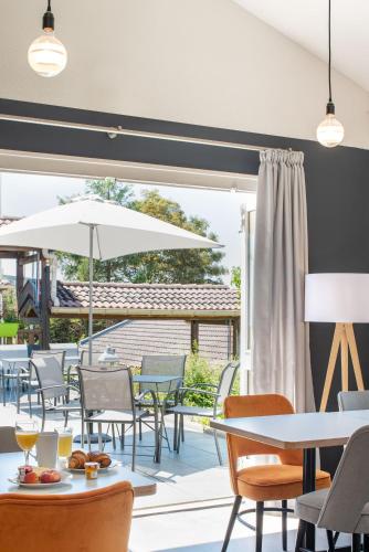 a restaurant with tables and chairs and a patio at KYRIAD LYON EST – Saint Quentin Fallavier in Saint-Quentin-Fallavier
