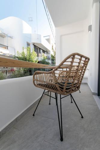 a wicker chair sitting on top of a balcony at Majestique of Naxos luxury suites in Naxos Chora
