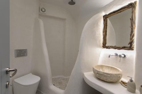 a bathroom with a sink and a toilet and a mirror at Majestique of Naxos luxury suites in Naxos Chora