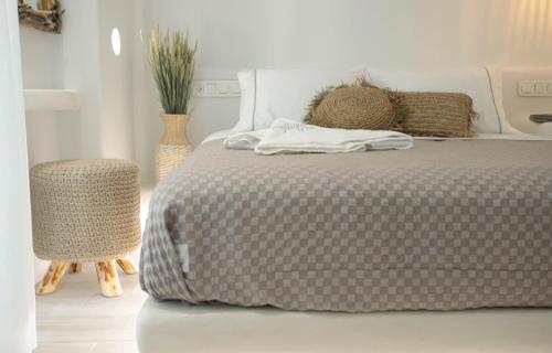 a bedroom with a bed and a table and a chair at Majestique of Naxos luxury suites in Naxos Chora