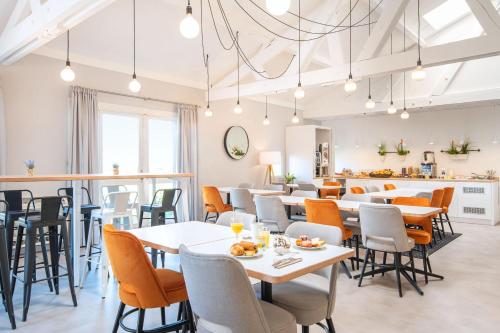 un restaurant avec des tables et des chaises ainsi qu'un bar dans l'établissement KYRIAD LYON EST – Saint Quentin Fallavier, à Saint-Quentin-Fallavier