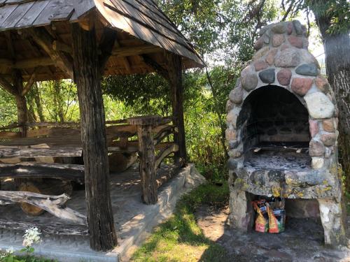 an outdoor brick oven with a wooden roof at Zielona Dolina in Rutka Tartak