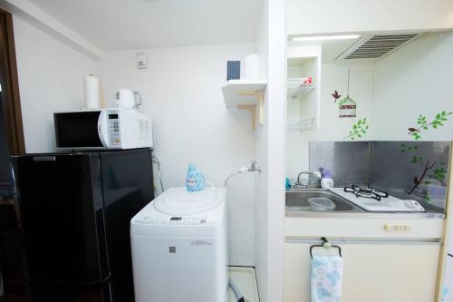 a small kitchen with a sink and a microwave at Cozy house 305 free wifi a rented electric bicycle in Kyoto