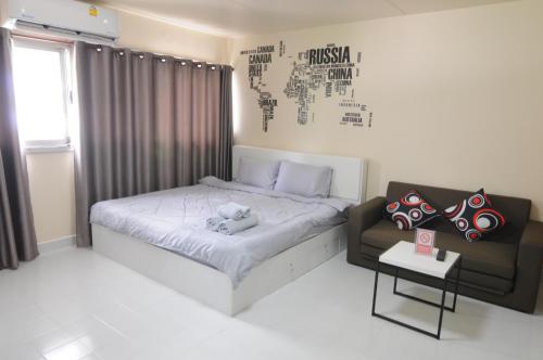 a small bedroom with a bed and a couch at ป๊อปปูล่า คอนโด อาคาร C4 impact เมืองทองธานี in Nonthaburi