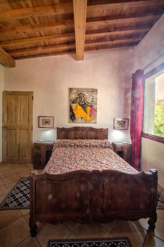 une chambre avec un grand lit en bois dans une pièce dans l'établissement Duché d'Uzès Villa Celina Avenue des Cévennes, à Uzès