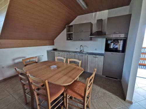 a kitchen and dining room with a wooden table and chairs at Pohorje in Spodnje Hoče