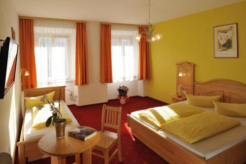 Un dormitorio con 2 camas y una mesa con una mesa. en Gasthof Sonne, en Imst