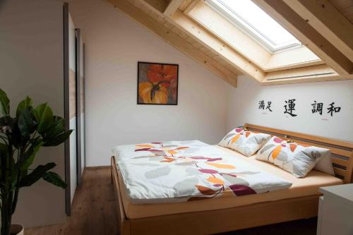 ein Schlafzimmer mit einem Bett in einem Zimmer mit einem Fenster in der Unterkunft Ferienwohnung Hanne in Untrasried