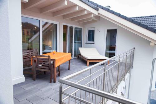eine Terrasse mit einem Tisch und Stühlen auf dem Balkon in der Unterkunft Ferienwohnung Hanne in Untrasried
