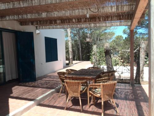 a patio with a table and chairs on a deck at Casa Barca Cala Saona in Cala Saona