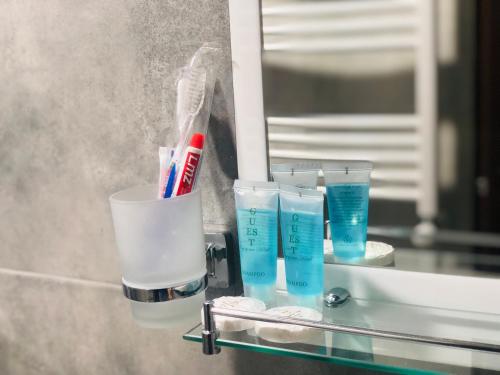 a glass shelf with toothbrushes and glasses on a mirror at Paradise Kazbegi in Stepantsminda