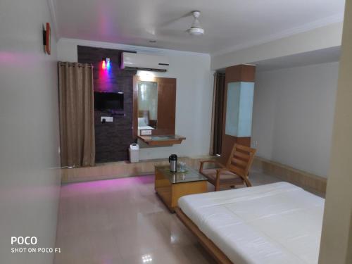 a bedroom with a bed and a table and a chair at Hotel Easy Retreat in Vapi