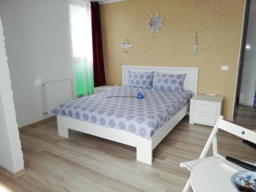 ein Schlafzimmer mit einem weißen Bett mit einer blauen Decke in der Unterkunft Blue Marina Clubbing Studio 5 in Mamaia
