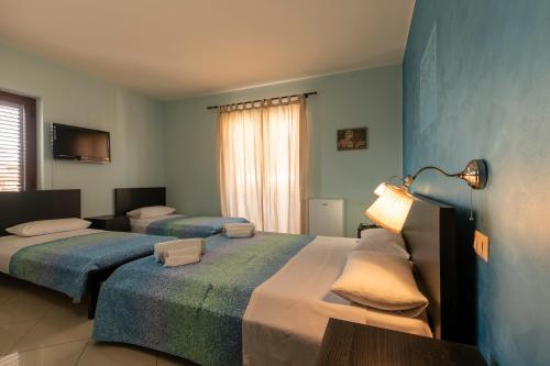 2 Betten in einem Zimmer mit blauen Wänden in der Unterkunft Sun and Beach in Catona