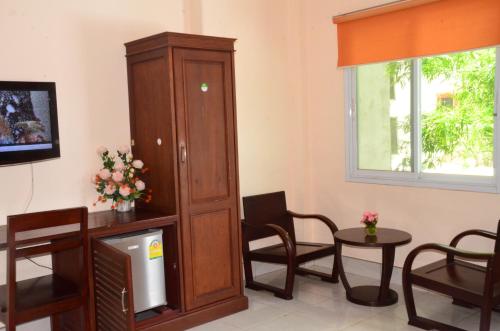 a living room with a tv and a large wooden cabinet at Hoang Kim Hotel in Vientiane