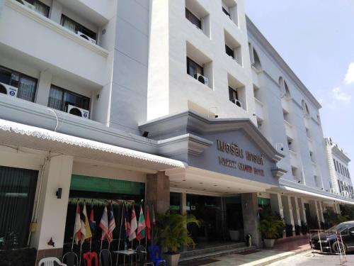 a large white building with flags in front of it at Merlin Grand Hotel in Hat Yai