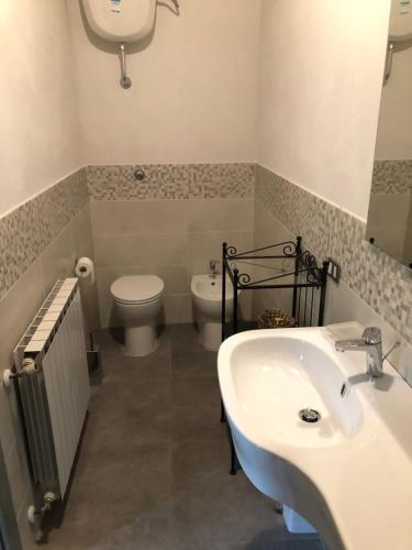 uma casa de banho com um lavatório branco e um WC. em Agriturismo Scorgiano em Scorgiano