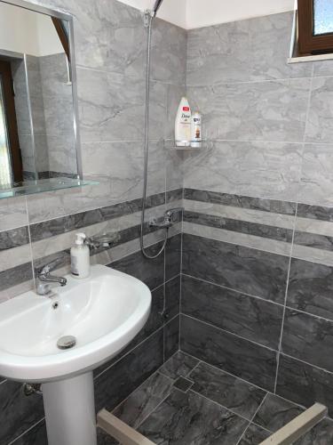 W łazience znajduje się umywalka i prysznic. w obiekcie Guest House Genti w mieście Berat
