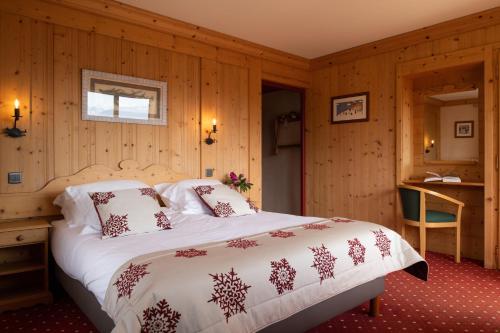 um quarto com uma cama grande num quarto com paredes de madeira em Le Chamois d'Or em Cordon