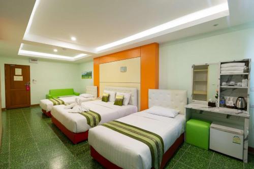 バンコクにあるラッキー グリーン ビューのベッド3台とキッチンが備わるホテルルームです。