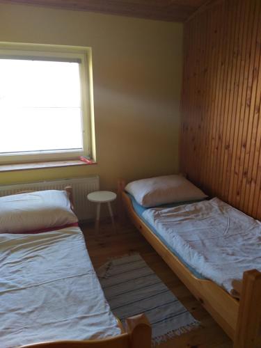 two beds in a small room with a window at Apartman Ala in Poprad