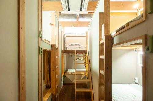 a tiny house with a staircase and a bunk bed at Fukuoka Guesthouse HIVE in Fukuoka