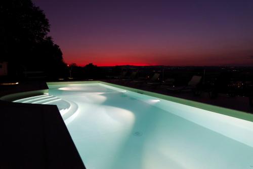 a swimming pool lit up at night at Tenuta Lisetta in Monterotondo