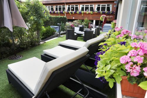 a patio with tables and chairs and flowers at Hotel de la Jamagne & Spa in Gérardmer