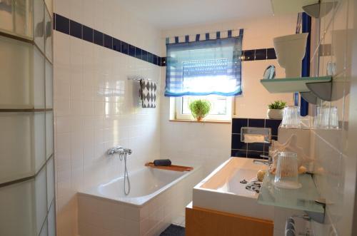 a bathroom with a tub and a sink and a window at Ferienhaus Luzia in Darscheid