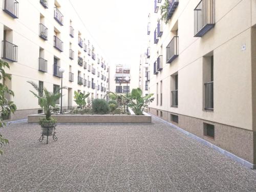 un cortile vuoto con una panchina di fronte agli edifici di Apartamento zona Palacio de las Dueñas y las Setas a Siviglia