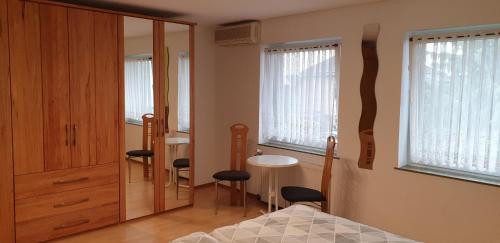 a bedroom with a bed and a table and windows at Gästezimmer Junglas in Bornheim