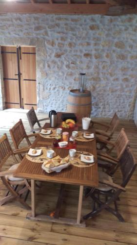 a wooden table with food on it in a room at Au cœur des vignobles in Saint-Estèphe