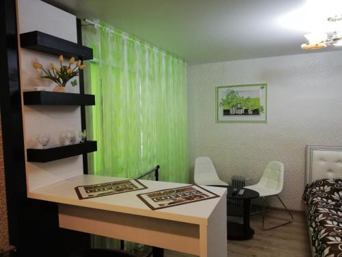a room with a table and a green curtain at Apartaments in Borisov in Borisov