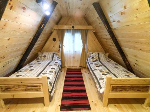 two beds in a tree house with a window at Etno selo Smrčevo brdo in Žabljak