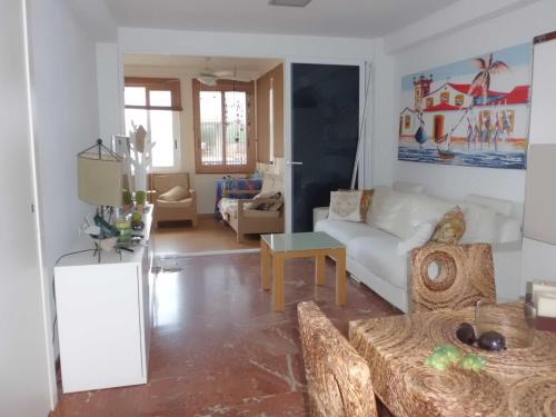 Agua Marina في آريناليس ديل سول: غرفة معيشة مع أريكة بيضاء وطاولة