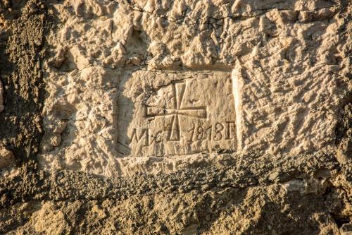 a stone relief of a man and a cross at Etno selo Smrčevo brdo in Žabljak