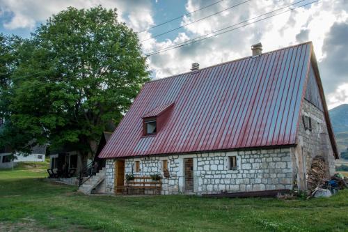 an old stone barn with a red roof at Etno selo Smrčevo brdo in Žabljak