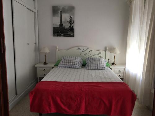 1 dormitorio con 1 cama con colcha roja y blanca en PRIMERA LINEA DE PLAYA, VISTAS AL MAR, en Algarrobo Costa
