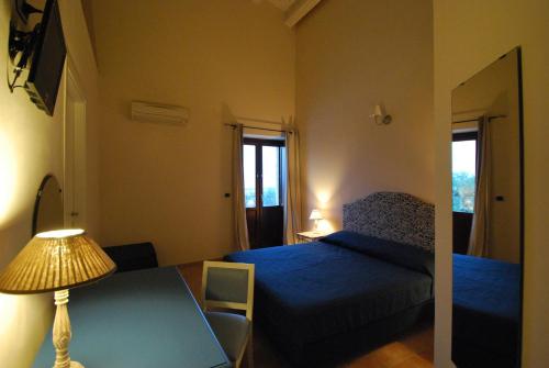 a bedroom with a bed and a table with a lamp at Pantanelli Di Vendicari in Casa Maccari