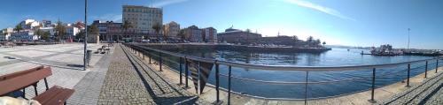 a view of a river with a pier and buildings at O Camiño in Ferrol