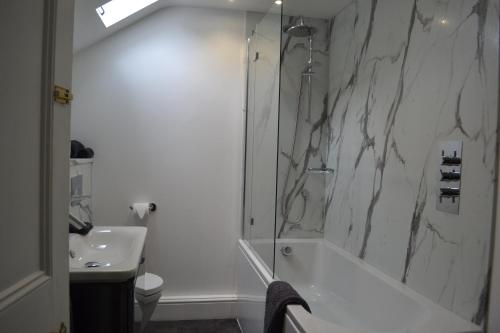 a bathroom with a shower and a tub and a sink at Coed-y-Fron in Betws-y-coed